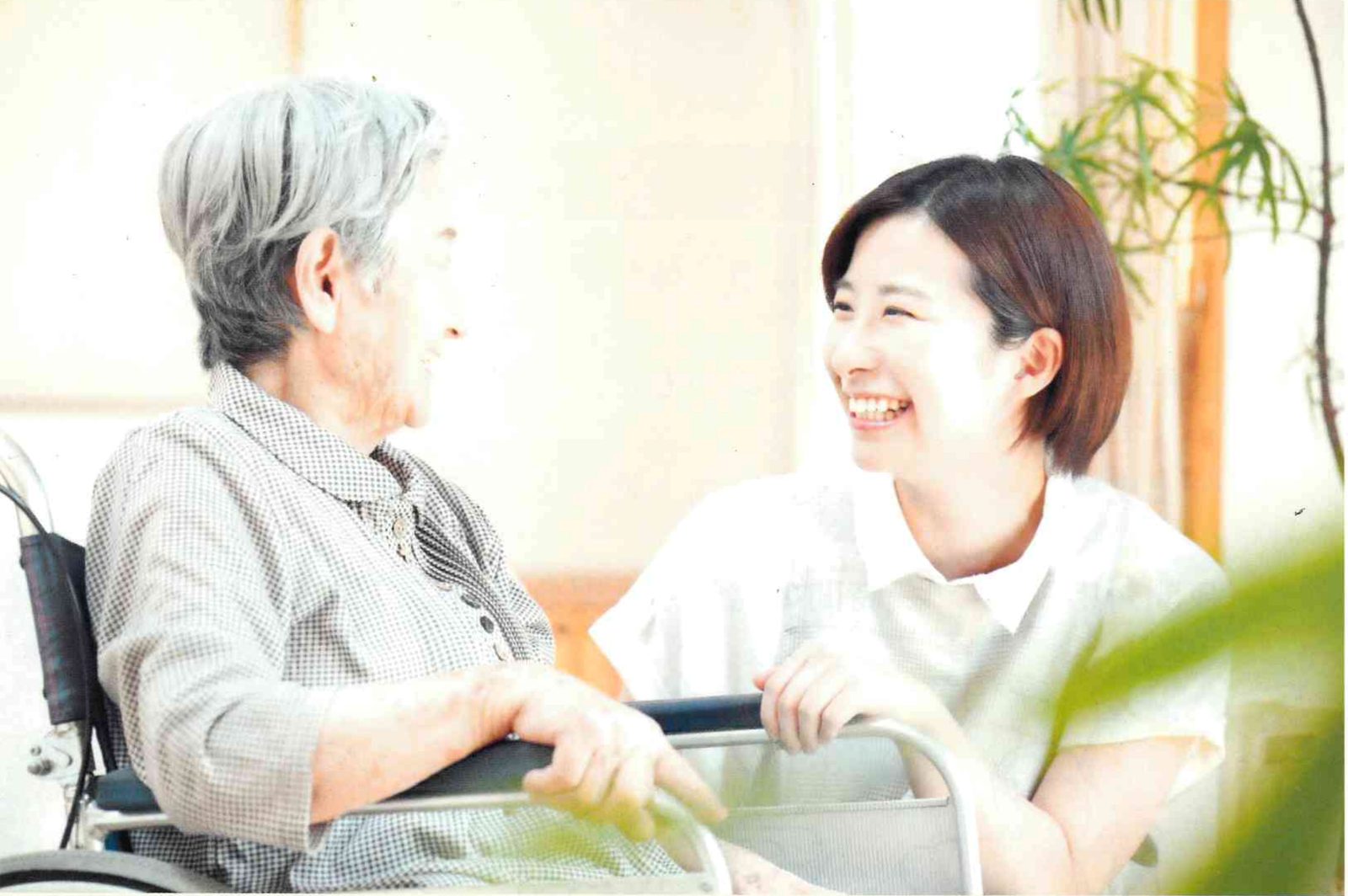 車いすのご利用者様と笑顔で話す訪問介護スタッフ